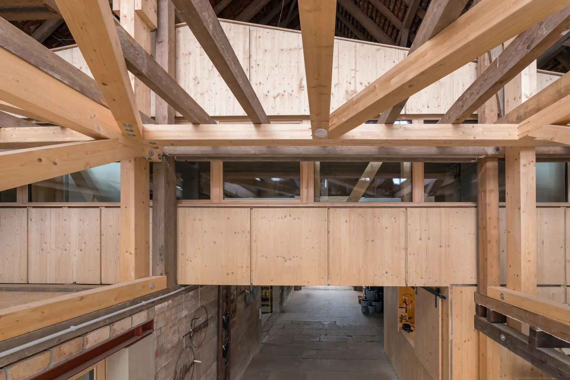 Das Foto zeigt den Innenraum einer Scheune mit einem Einbau aus Holz, der wie ein kleines Haus im Haus gestaltet ist.