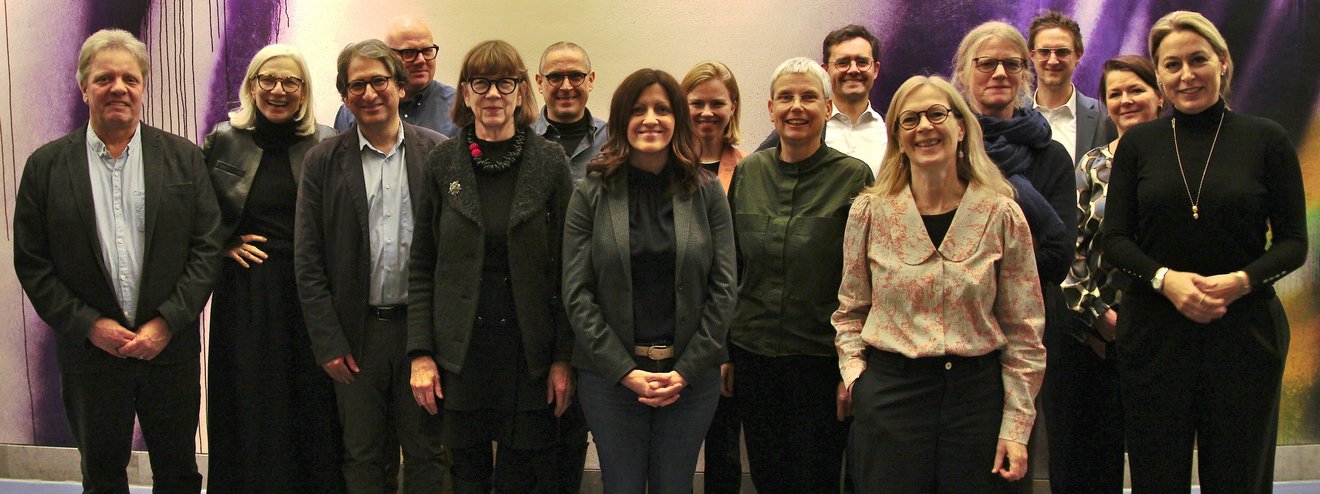 Gruppenfoto vor einer mit Graffitikunst gestalteten Wand.