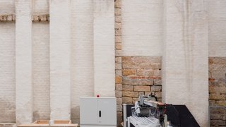 Das Foto zeigt einen Abschnitt der Mauer, die den Innenhof abschließt. Sie ist wie eine Collage aus verschiedenen Materialien zusammengesetzt.